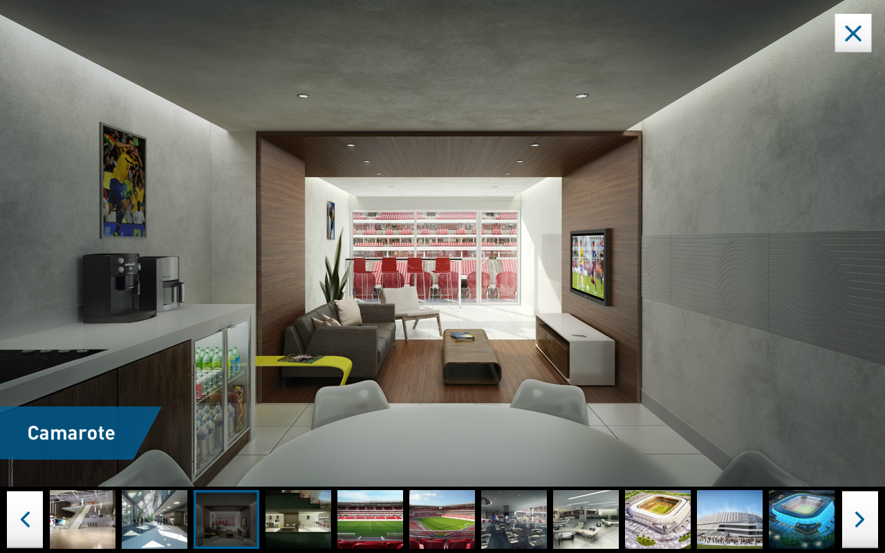 360° camarote view — modern luxury box suite interior with sofa, TV, kitchenette and a window overlooking the pitch, with thumbnail strip below