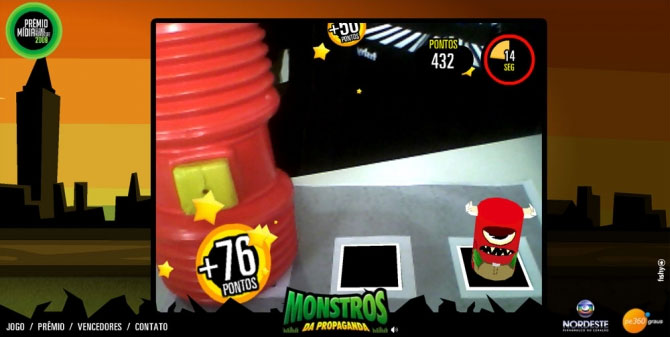 Active gameplay — red toy hammer hitting a virtual monster mid-air, score 432 pontos, +76 pontos hit feedback, 14 seconds remaining on the countdown