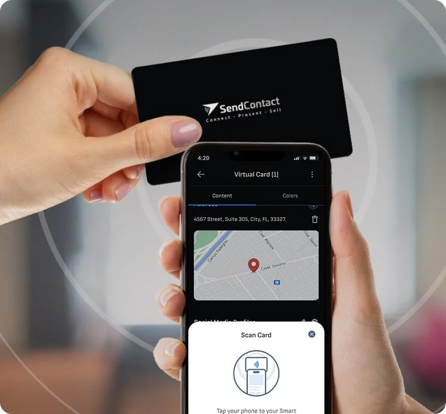 Physical product in use — two hands holding a black SendContact NFC smart business card above a smartphone. The phone screen displays the Virtual Card view with an address map and a Scan Card overlay prompting the user to tap their device.